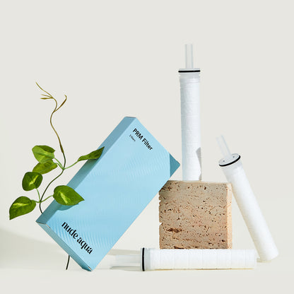 Nude Aqua water filter components including a filter cartridge, sponge, and packaging on a light background.
